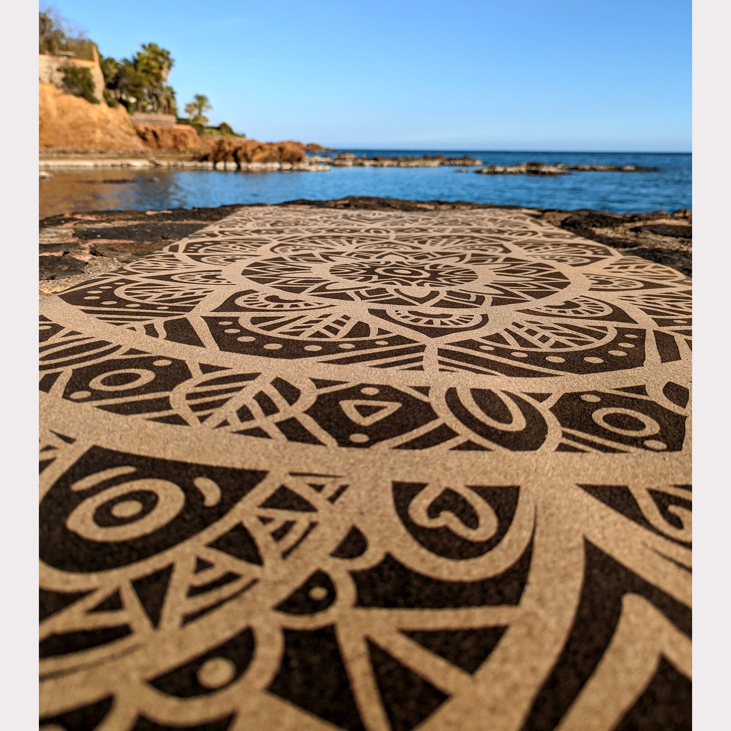 Close-up of the MandaLove ZenMotion cork yoga mat with a serene sea background.