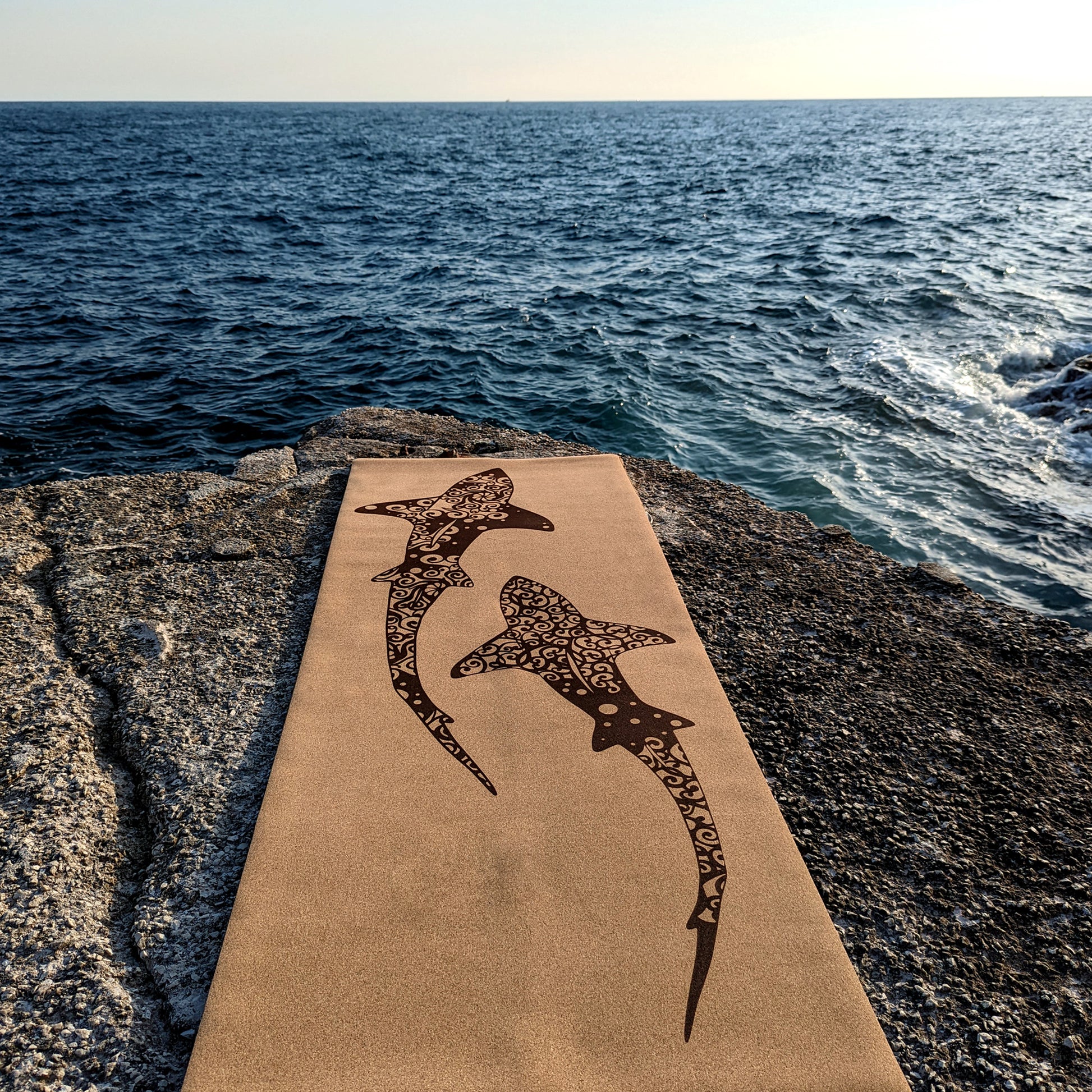 Close-up of the Shoal ZenMotion cork yoga mat placed against a seaside background.