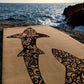 Close-up of the top of the Shoal ZenMotion cork yoga mat placed against a seaside background.