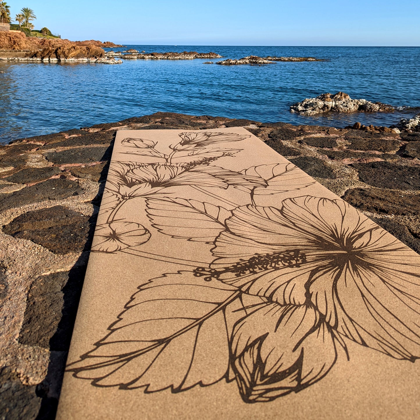 Close-up of the Summer Flowers ZenMotion cork yoga mat placed against a tranquil sea background.