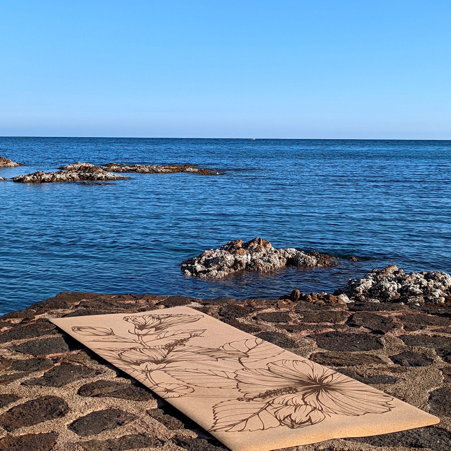 Picture of the Summer Flowers ZenMotion cork yoga mat placed against a tranquil sea background.